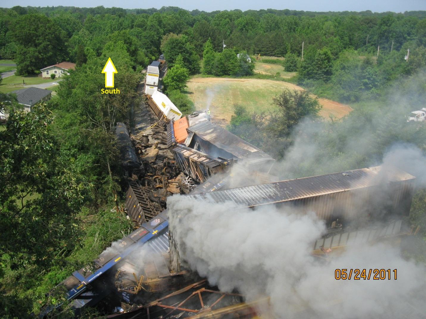 Photo with view of accident site showing derailed cars from the striking train