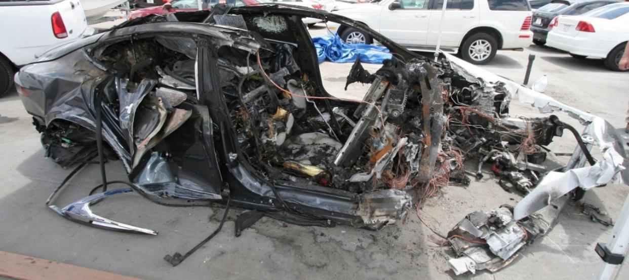 Right side of car, showing severe crash and fire damage.