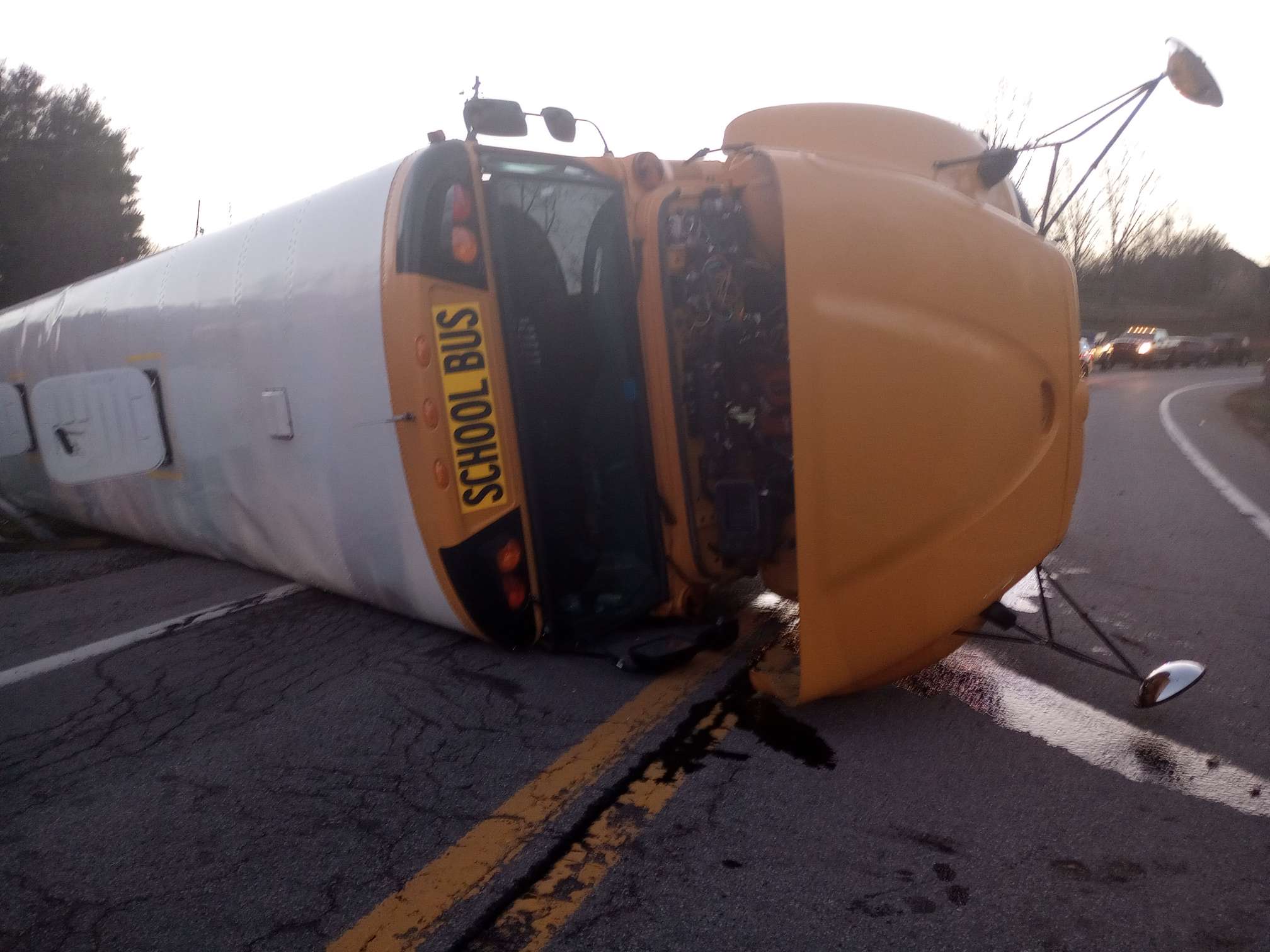 The Calhoun County, West Virginia, school bus on its side across both lanes of the roadway.